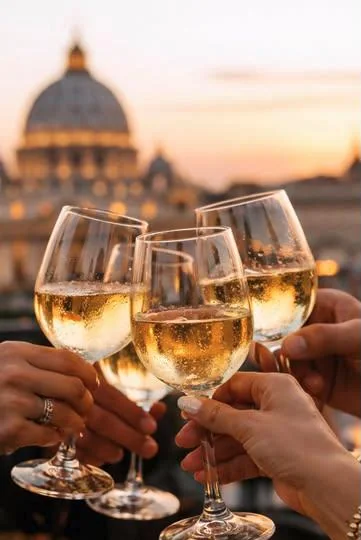 Glasses raised at sunset on a Roman terrace, with the dome of St Peter's behind.